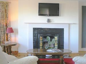 un soggiorno con camino e TV sopra di esso di Werescote View a Burlescombe