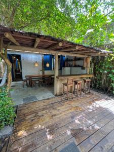 una terraza de madera con mesa y sillas. en Casa do Rio, en Caraíva