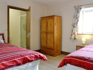 1 dormitorio con 2 camas y armario de madera en The Parlour - Op4, en Carmarthen