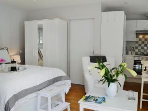 Un dormitorio con una cama blanca y una mesa con una planta en Petit Knowle, en Cuckfield