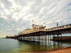 a pier with a building on it in the water at Petit Knowle in Cuckfield