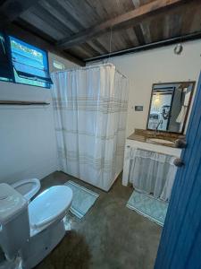 a bathroom with a toilet and a sink and a mirror at Casa do Rio in Caraíva