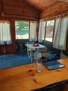 a laptop computer sitting on a wooden table in a cabin at Rustik Palace in El Bolsón
