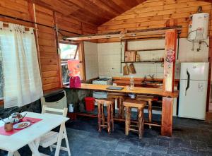 eine Küche mit einem Tisch und Stühlen sowie einem Kühlschrank in der Unterkunft Rustik Palace in El Bolsón