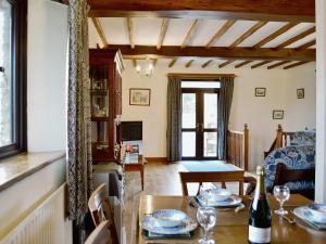 a living room with a table and a dining room at Rose Bank Cottage - W4218 in Lewdown