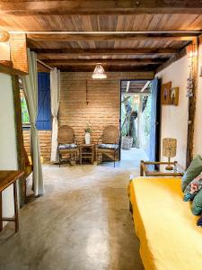 a bedroom with two beds and a table and chairs at Casa do Rio in Caraíva