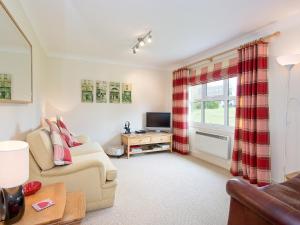 uma sala de estar com um sofá e uma televisão em Jubileum Lodge uk27999 em Watton