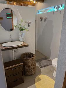 La salle de bains est pourvue d'un lavabo, d'un miroir et de toilettes. dans l'établissement Casa do Rio, à Caraíva