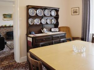 a dining room with a table and plates on a wall at Isfryn in Llanystumdwy