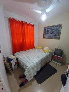 Dormitorio pequeño con cama y TV en Apto Texas em Balneário Camboriú-SC, en Balneário Camboriú