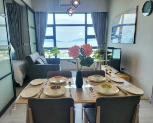 a dining room table with chairs and a large window at Kota Kinabalu Jesselton Quay Seaview with washing machine in Kota Kinabalu