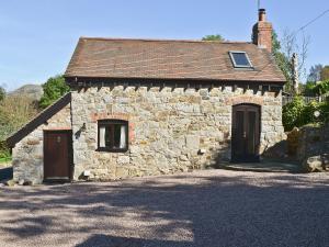 a stone house with two doors and a driveway at Angel Barn in Farden