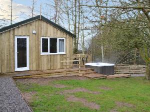 a small wooden house with a deck and a fountain at Treehouse Cabin in Westward
