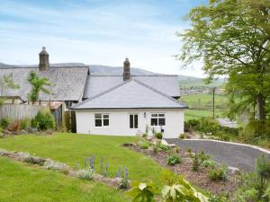 uma casa branca com um jardim em frente em Ferncliffe Cottage em Snitter