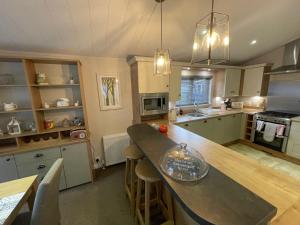 a kitchen with a large island in the middle at Indulgence lakeside lodge i1 with hot tub, private fishing peg situated at Tattershall Lakes Country Park in Tattershall
