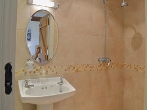 a bathroom with a sink and a mirror at Jumbos Stable in Alderminster