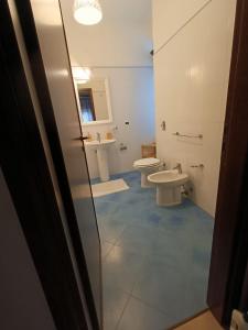 uma casa de banho com 2 WC, um lavatório e uma porta em B&B Margherita em Bagheria