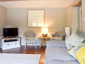 a living room with a couch and a tv at Prospect Cottage in Kettlewell