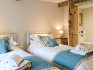 a bedroom with two beds with towels on them at Prospect Cottage in Kettlewell