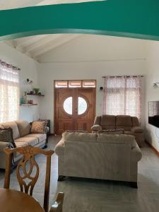 a living room with two couches and a window at Travellers Villa in Roseau