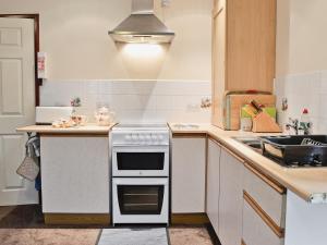 a kitchen with a stove and a counter top at Oakwood Venbridge Farm in Cheriton Bishop