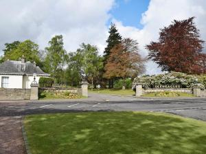 a house on a street with a gate and a driveway at Bracken Log Cabin - S4468 in Glenfarg