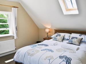 a bedroom with a bed and a window at Bramble Cottage in Wimborne Minster