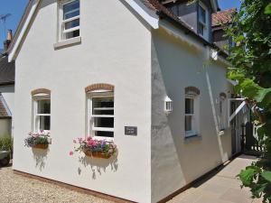 una casa blanca con flores en vidrieras en Bramble Cottage en Wimborne Minster