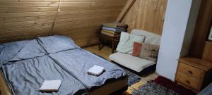 ein kleines Schlafzimmer mit einem Bett und einem Stuhl in der Unterkunft Pace in Kuvaszó-Casă la cheie in Filia