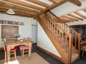 a wooden staircase in a room with a table and a desk at Cefn Bach in Capel Garmon