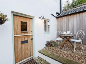 a table and two chairs next to a door at The Wee House On The Hill in Wirksworth