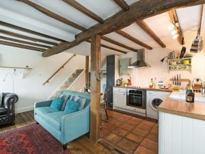 a kitchen and living room with a blue couch at The Wee House On The Hill in Wirksworth