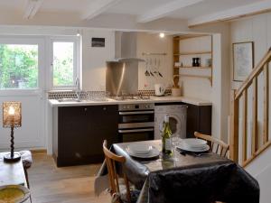 a kitchen with a table and a stove top oven at Duke Street in Lostwithiel