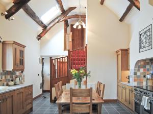 a kitchen with a wooden table and chairs at Ysgubor in Harlech