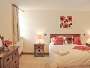 a bedroom with a large bed with red pillows at Ysgubor in Harlech