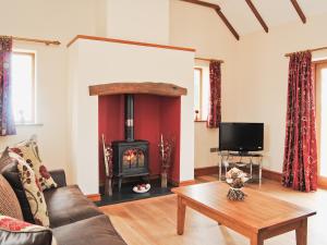 a living room with a fireplace and a couch at Ysgubor in Harlech