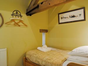 ein kleines Schlafzimmer mit einem Bett und einem Bild an der Wand in der Unterkunft St Vincent in Plaish