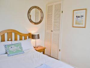 a bedroom with a bed and a mirror and a table at Shorewaters in Appledore