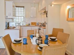 a kitchen with a wooden table with chairs and a dining room at Shorewaters in Appledore