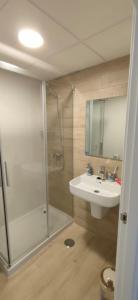 een badkamer met een douche en een wastafel bij Jardines del Lago de Costa Ballena in Chipiona