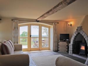 a living room with a couch and a fireplace at Bequia - Reet in Frodesley