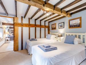 Habitación con 2 camas y vigas de madera. en Mill Cottage, en Bampton