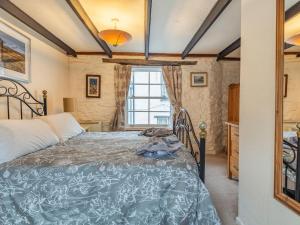 a bedroom with a bed and a window at Talland House in Polperro