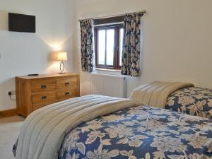 a bedroom with two beds and a window and a dresser at Swallows Retreat in Hartland