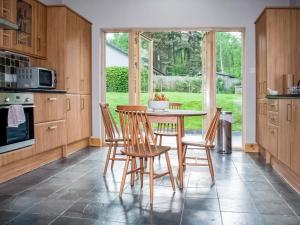a kitchen with a table and chairs and a window at Treetops in Newtonmore