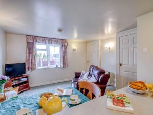 uma sala de estar com um sofá e uma mesa em Blossom Cottage em Goldsborough