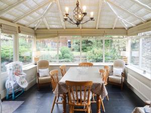 una sala da pranzo con tavolo, sedie e finestre di Hallgarth House a Pickering