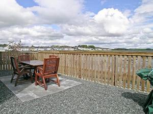 a patio with a table and chairs and a fence at Seaview in Garlieston