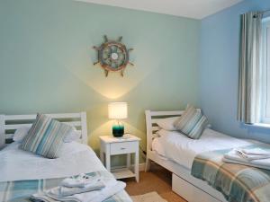 two beds in a room with a clock on the wall at Seaview in Garlieston