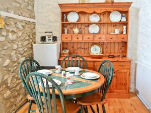 a dining room with a table and four chairs at The Stables At Old Vicarage Cottage in Abergele